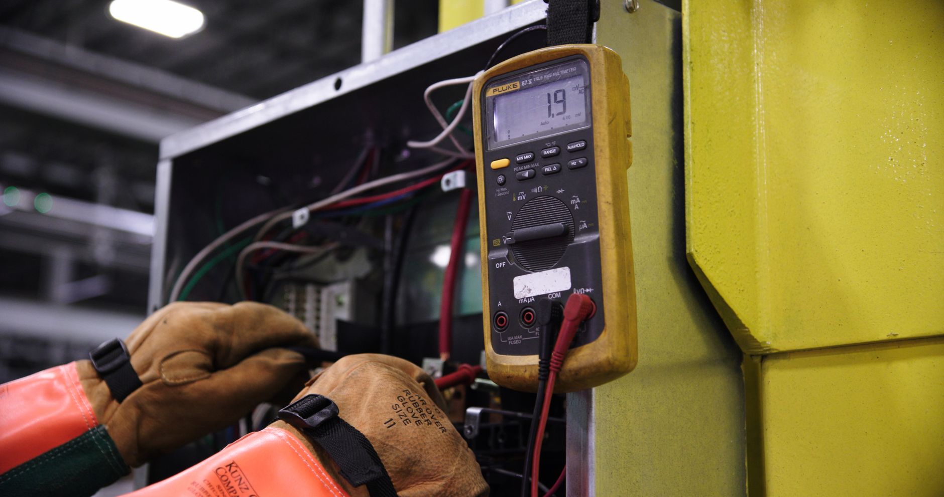 Eletricista realizando manutenção em quadro elétrico